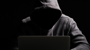 Suspicious person using a laptop.
