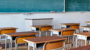 School classroom with rows of desks and chalkboard.