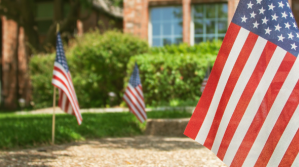 American flags line a walkway to a house.