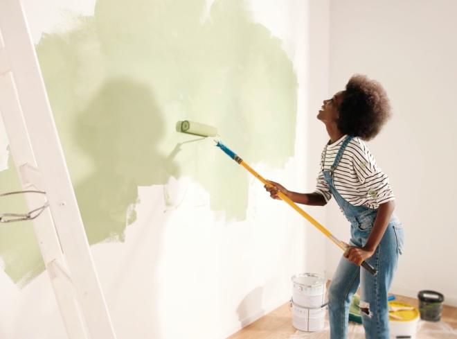 Girl painting a wall in her house